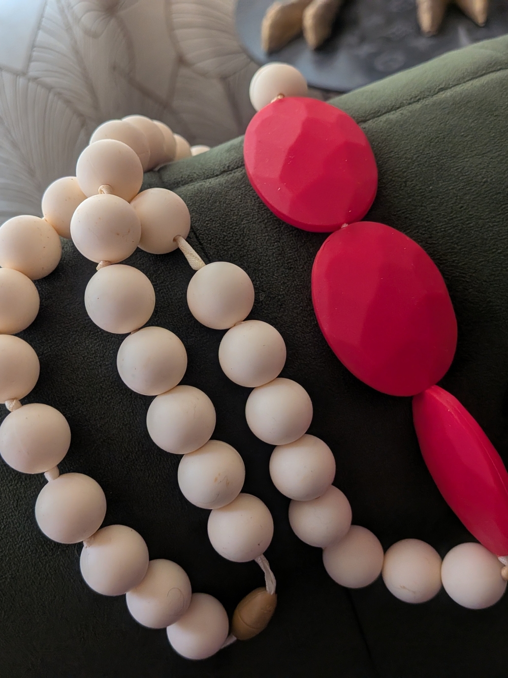 Chewbeads Greenwich teething necklace features ivory and red silicone beads